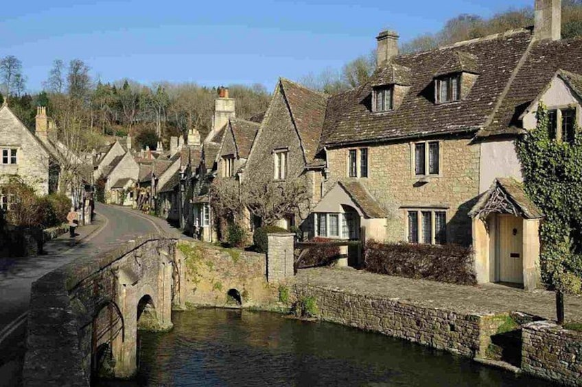 A quaint village with stone houses, a narrow waterway, and a bridge. 4
