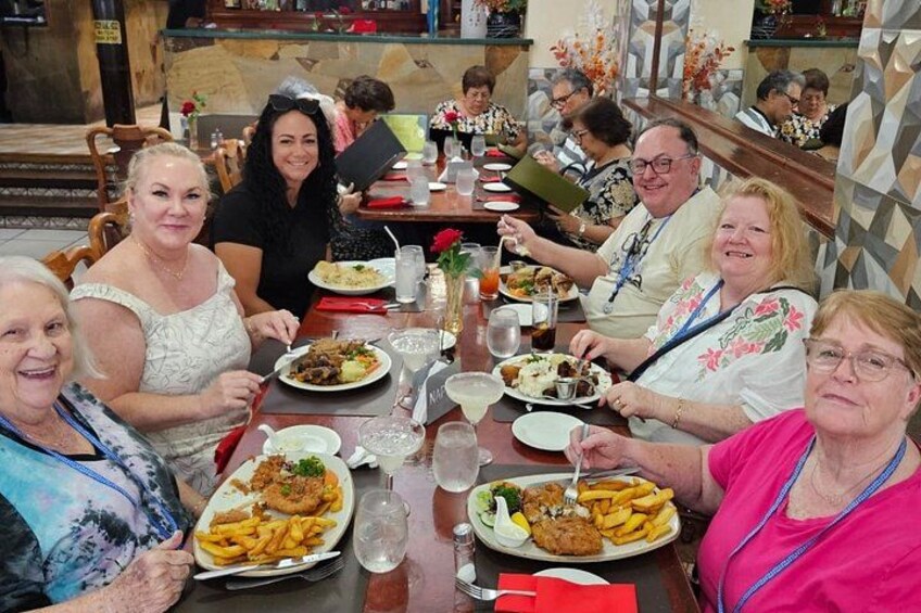A group of people dining at a restaurant with various dishes on the table. 3