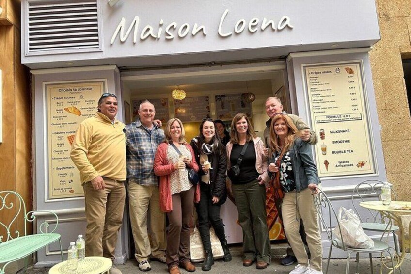 A group of people standing in front of Maison Loena, a cafe with outdoor seating. 4