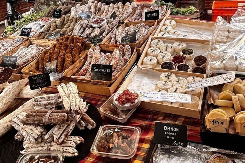A variety of dried fruits and nuts displayed in wooden crates and plastic containers at a market. 1