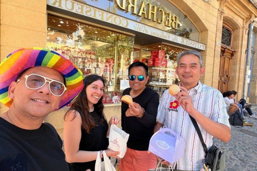 People in front of a bakery with a striped awning and a sign with the word 'Baker.' 2