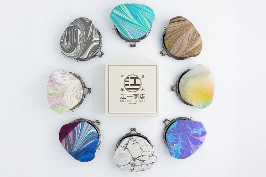A collection of eight uniquely patterned coin purses arranged in a circle around a central sign with Chinese characters. 3