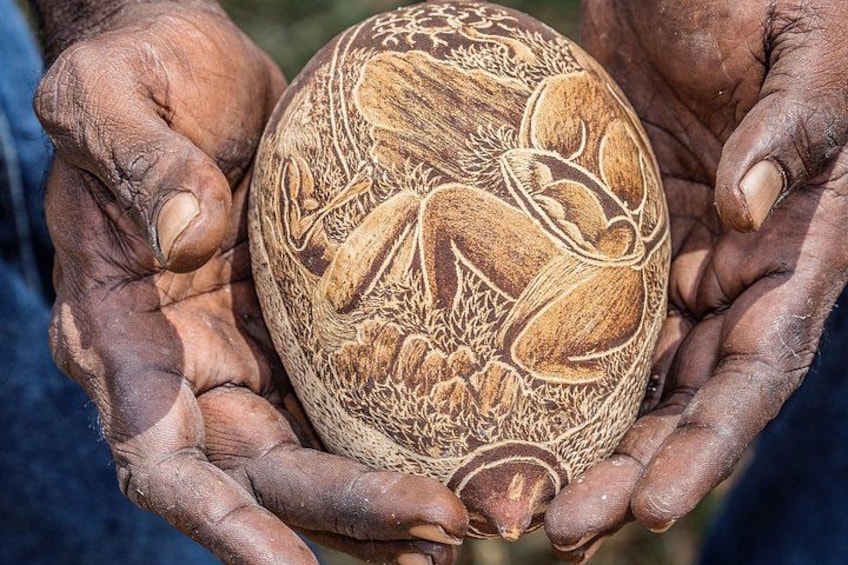 A carved wooden object held in hands. 4