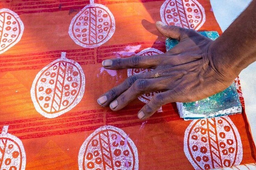 Hands on a patterned fabric with leaf designs. 3