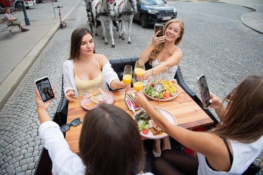 Three people sitting at an outdoor table with food and drinks, taking a selfie. 5