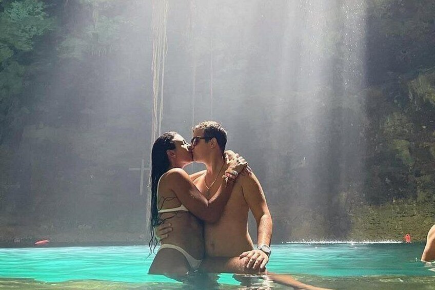 A couple embracing in a pool with a waterfall in the background. 5