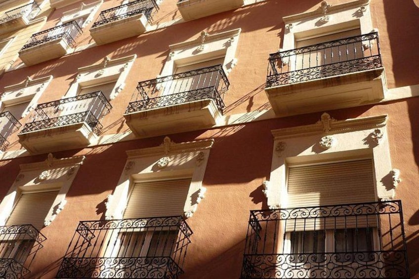 Fachada de edificio con varios balcones y barandillas de hierro decorativas. 2