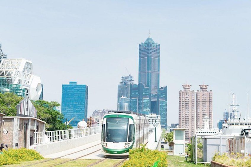 A train on tracks with a cityscape in the background. 3