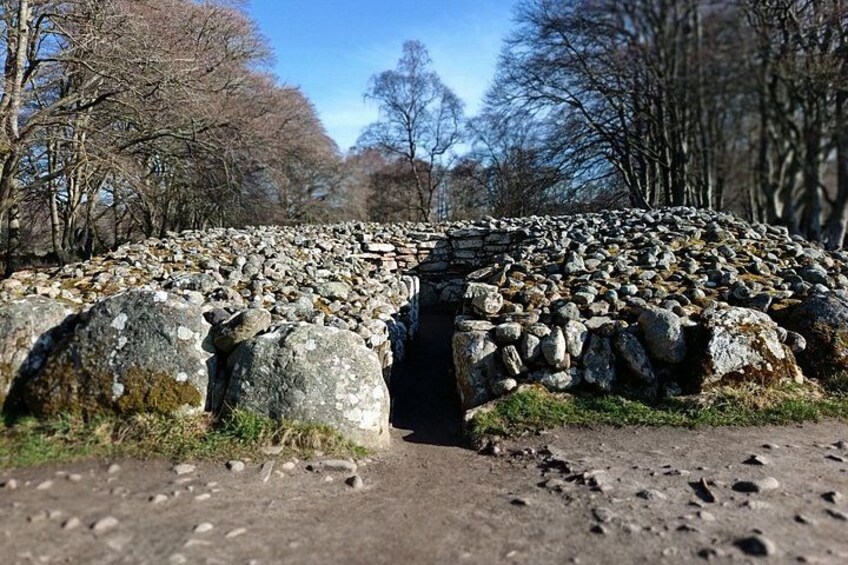 A stone bridge over a rocky path surrounded by trees. 3
