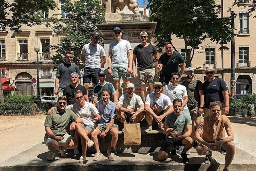 Een groep mensen die poseert op een openbaar plein, met een standbeeld op de achtergrond. 3