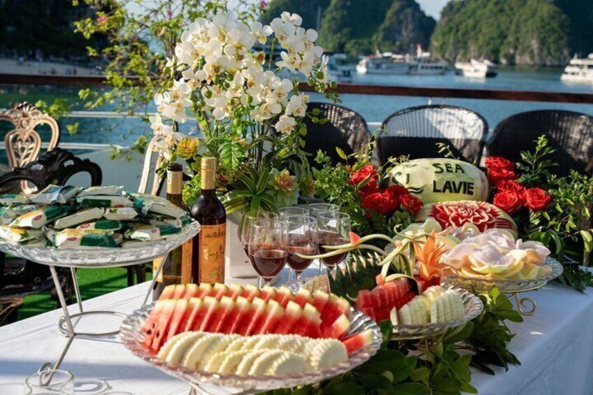 Een tafel met eten, drinken en bloemen aan het water. 2