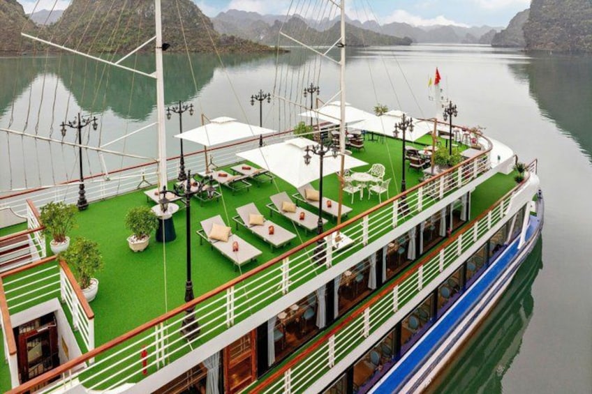 A river cruise ship with outdoor seating areas and a green deck. 2