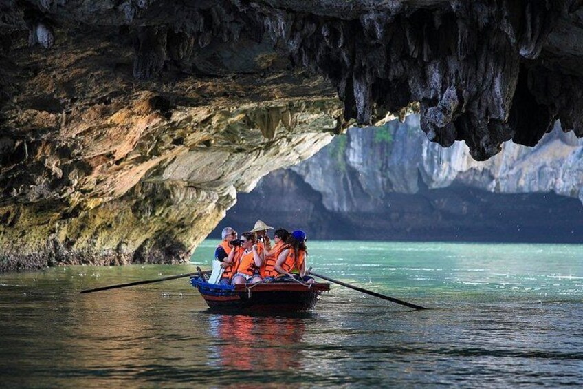 A group of people in a boat on a calm body of water, surrounded by rocky cliffs. 1