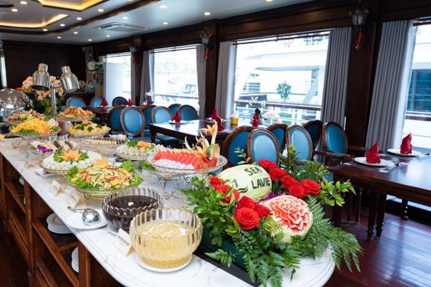 A buffet table with various dishes, a cake, and a floral centerpiece. 3