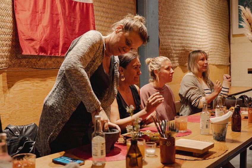 Un groupe de personnes participait à une activité culinaire autour d’une table en bois, où étaient disposés divers ustensiles de cuisine et ingrédients. 4