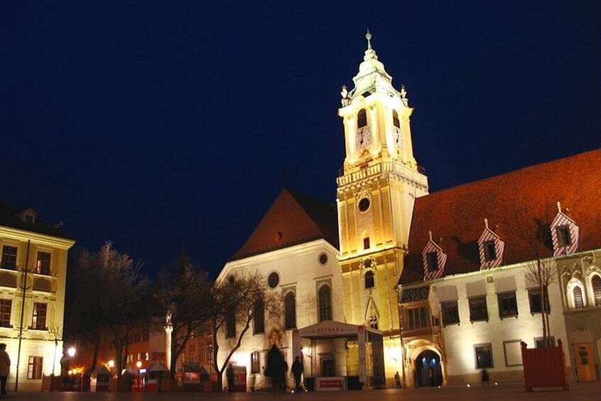 A historic building with a clock tower, illuminated by artificial lighting at night. 5