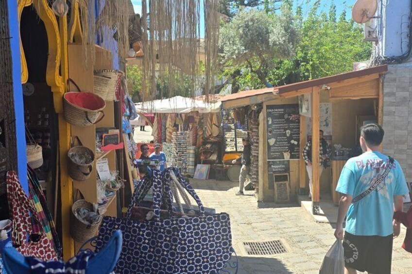 A market street with stalls selling bags and textiles. 5