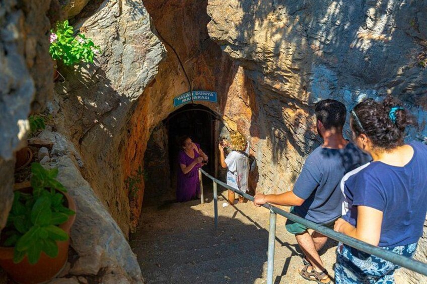 Eingang einer Höhle mit einem Schild, einer Geländer und Personen, die zusehen. 3