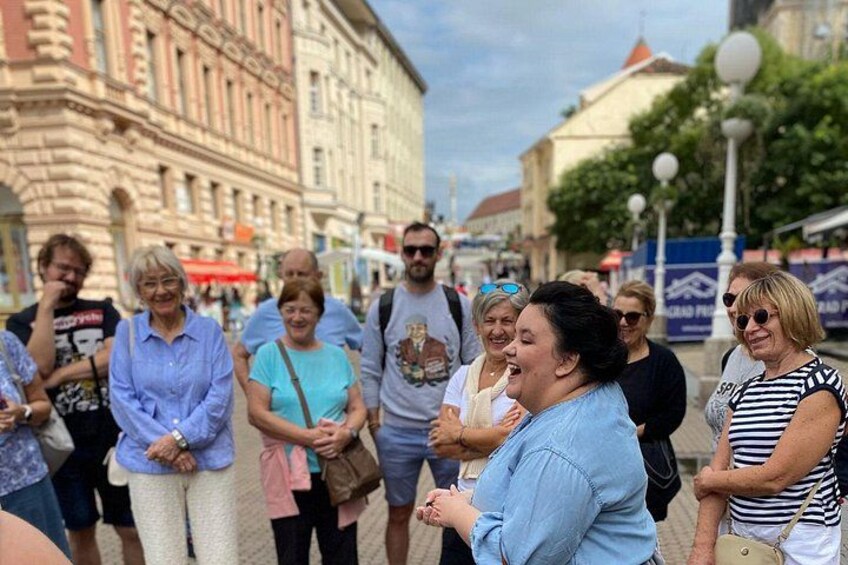 A group of people standing on a street with historic buildings in the background. 3
