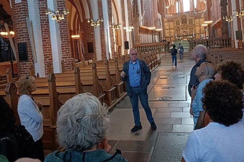 A church interior with pews, a high ceiling, and a central aisle. 3
