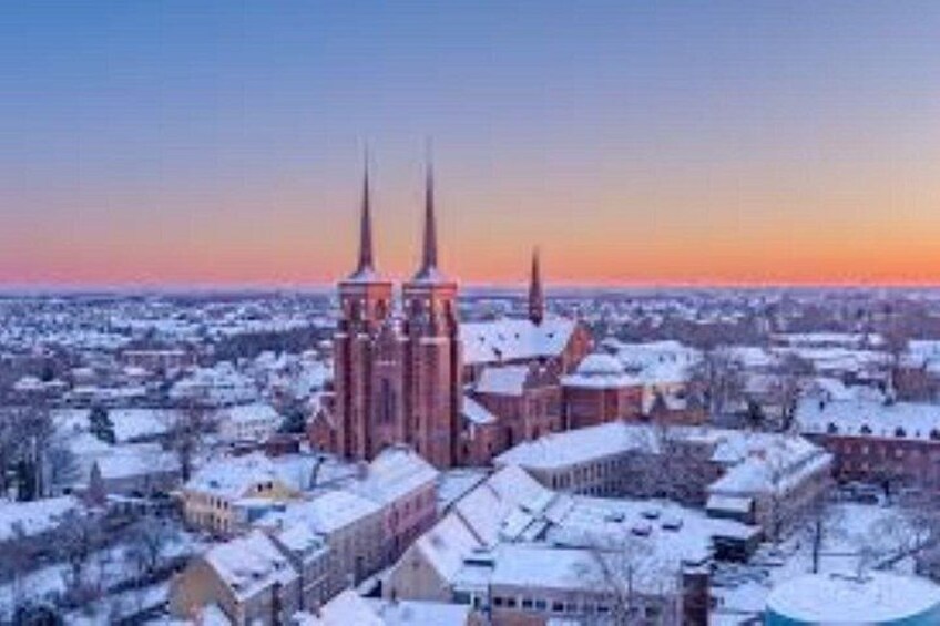 A cathedral with two spires, surrounded by snow-covered buildings. 4