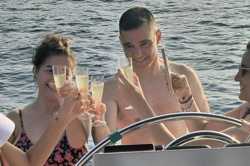 People on a boat, holding drinks, with water in the background. 3