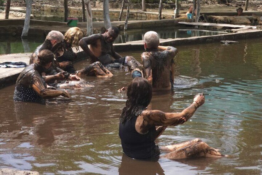 People bathing in a natural water body surrounded by trees. 4