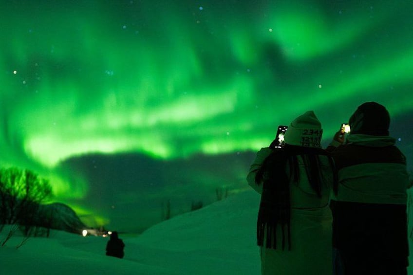 Two people taking photos of the Northern Lights. 1