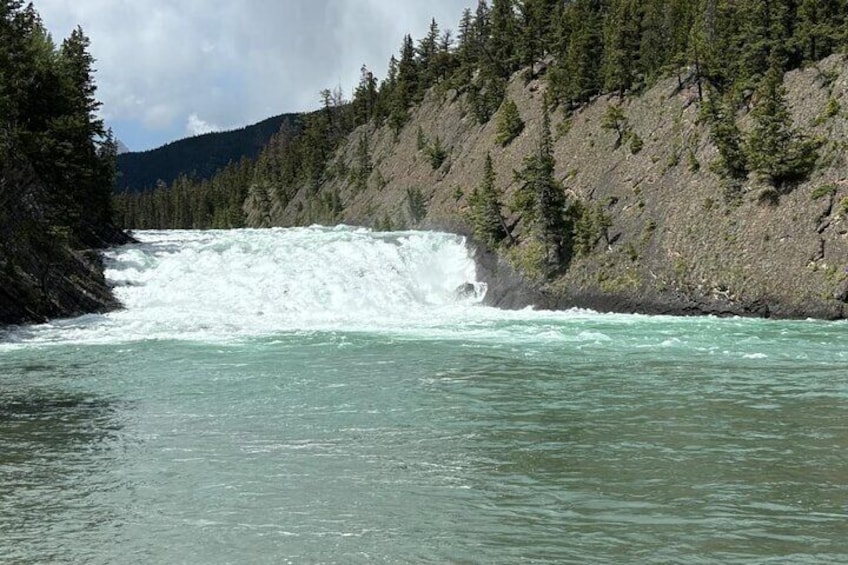 A river with a waterfall surrounded by dense forest and rocky terrain. 3