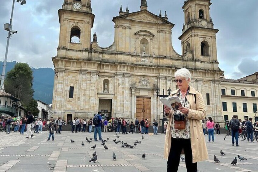 Una iglesia histórica con dos torres y una multitud de personas frente a ella. 1