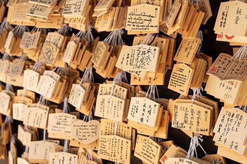 A wall of hanging wooden plaques with handwritten text. 2