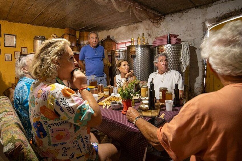 A group of people gathered around a table in a rustic setting with wooden walls and metal containers. 2