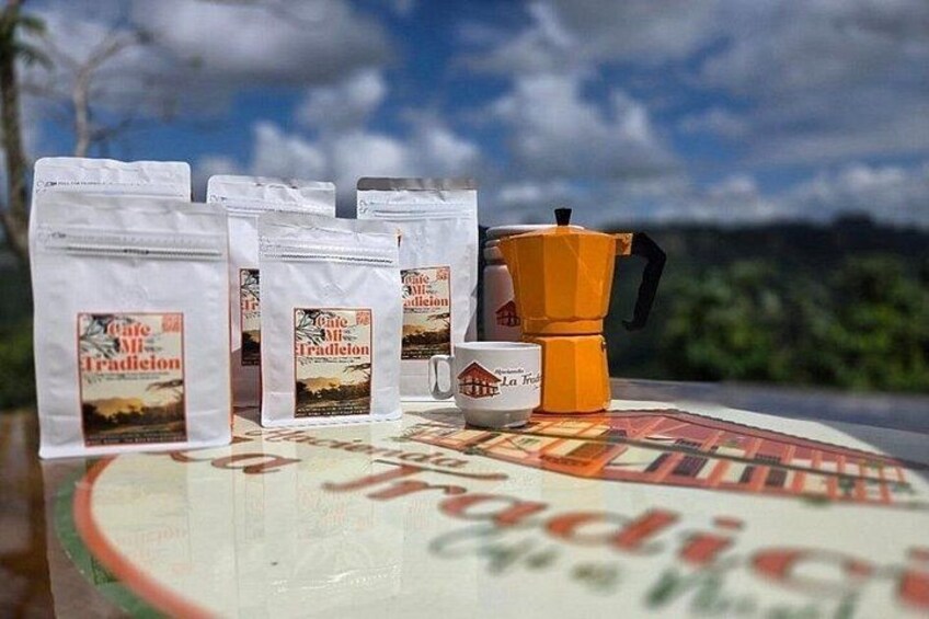 Coffee bags, a coffee pot, and a mug on a table with a scenic background. 1