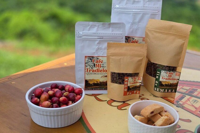 A table with coffee bags, a bowl of cherries, and a cup of biscotti. 5