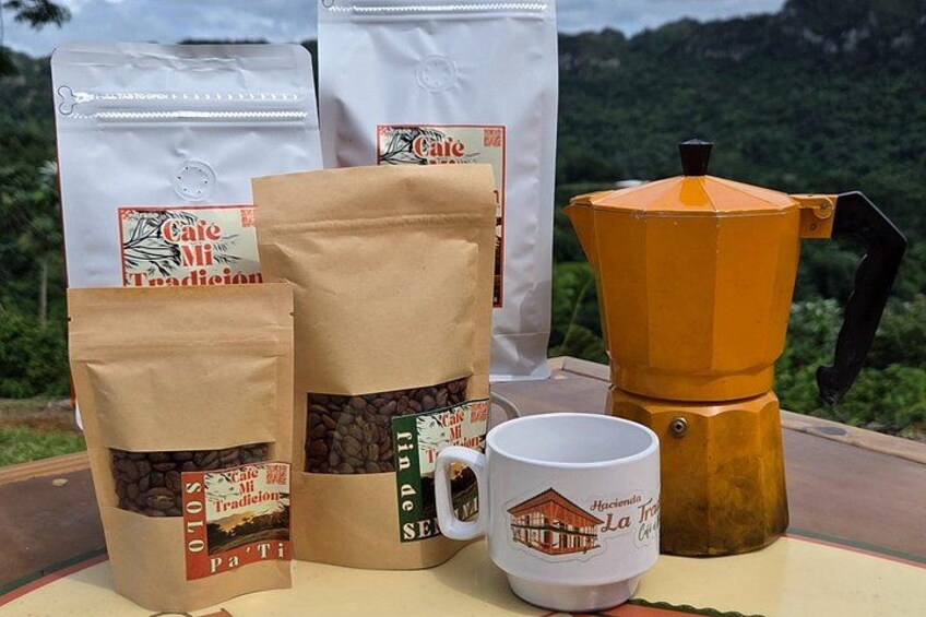 A coffee maker, a mug, and bags of coffee with labels. 4