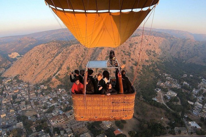 A hot air balloon with passengers over a mountainous landscape. 2