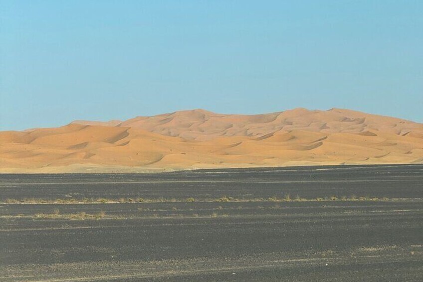 A desert landscape with sand dunes and a clear sky. 4