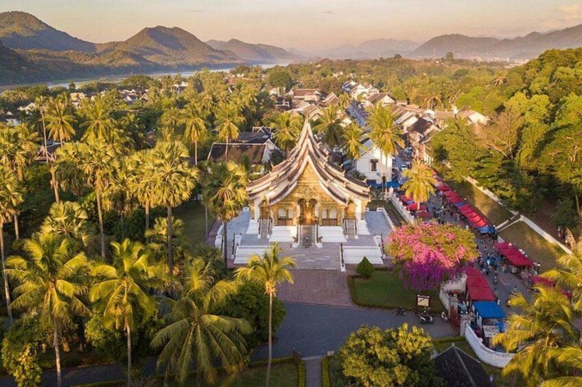 Un templo tradicional rodeado de palmeras y un paisaje montañoso. 1