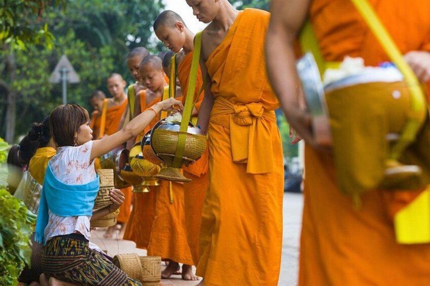 Monjes con túnicas anaranjadas realizando un ritual con un niño. 4