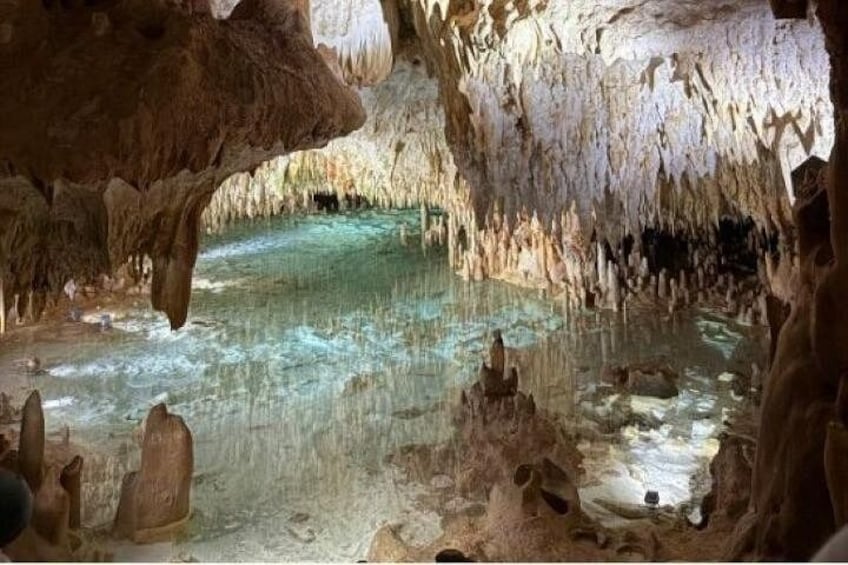 Una grotta con stalattiti e stalagmiti, acqua cristallina e formazioni rocciose. 1