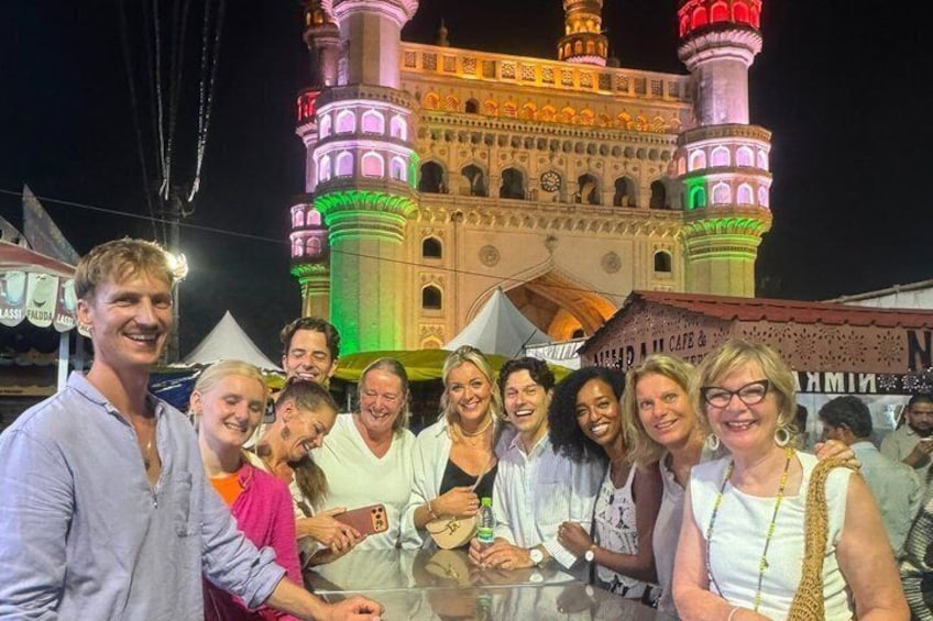 A group of people posing in front of a brightly lit building with multiple minarets. 2
