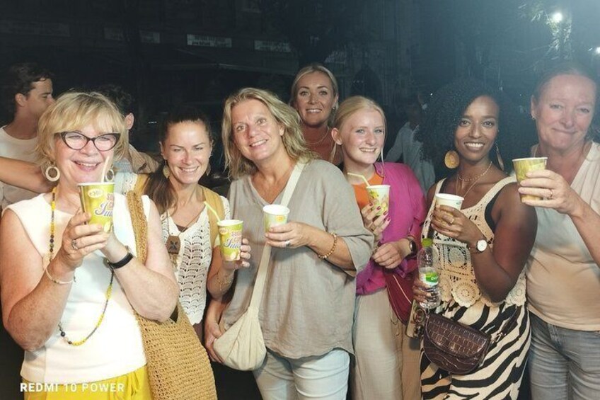 A group of people holding cups, likely at a social event. 3