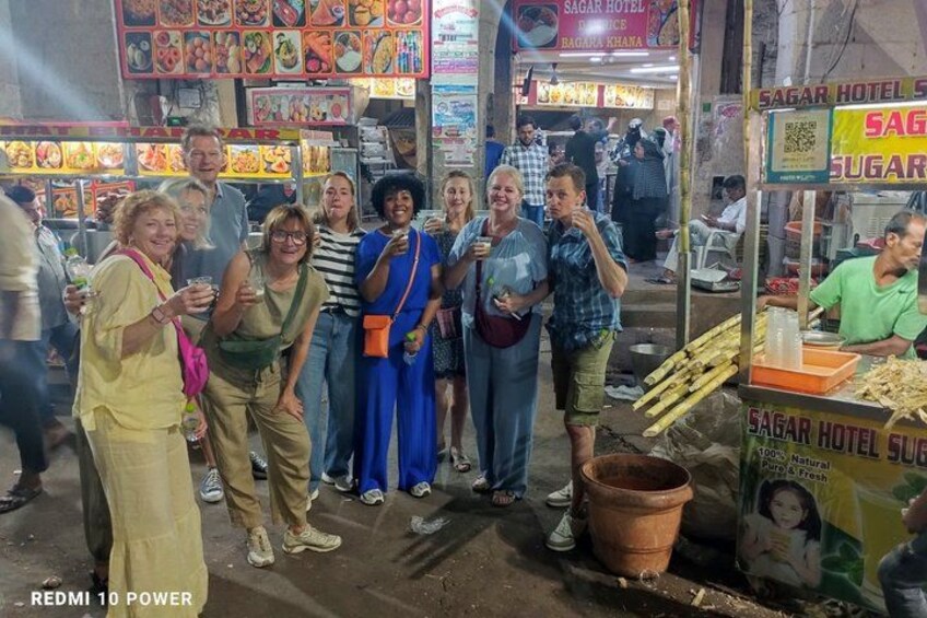 A group of people at a street food stall with a sign for Sagar Hotel Sugar. 3