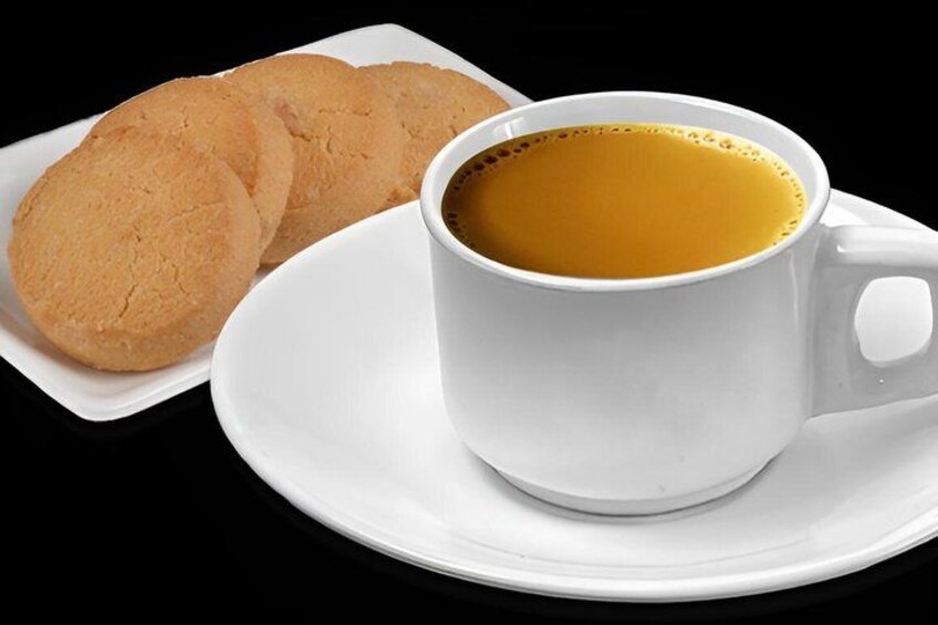 A white cup of coffee with a saucer and two cookies on a white plate. 5