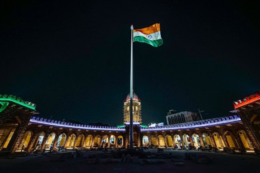 A night view of a building with a flagpole, illuminated by artificial lighting. 3