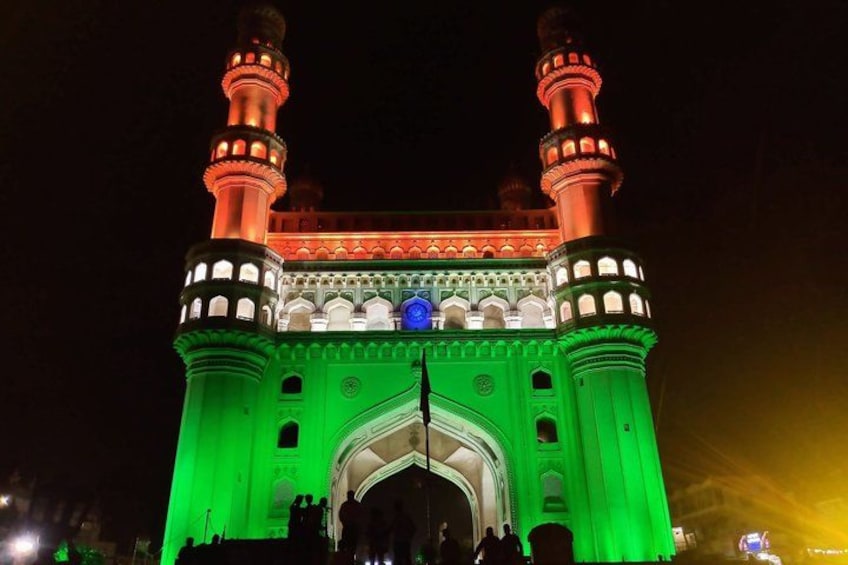 A brightly lit building with two towers and a central archway. 2