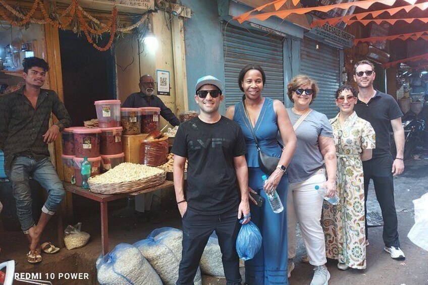 Un grupo de personas en un mercado, con sacos de mercancía y una tienda al fondo. 2
