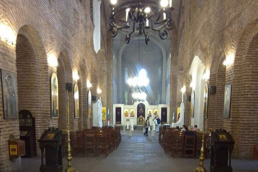A church interior with brick walls, arched windows, and a central altar. 3