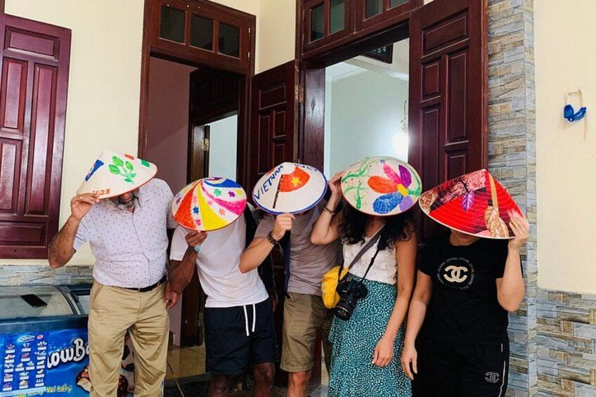 Un gruppo di persone che tiene ombrelli colorati di fronte a un edificio con porte in legno. 2