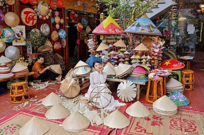 Een marktkraam met verschillende kegelvormige hoeden en traditionele Vietnamese decoraties. 2